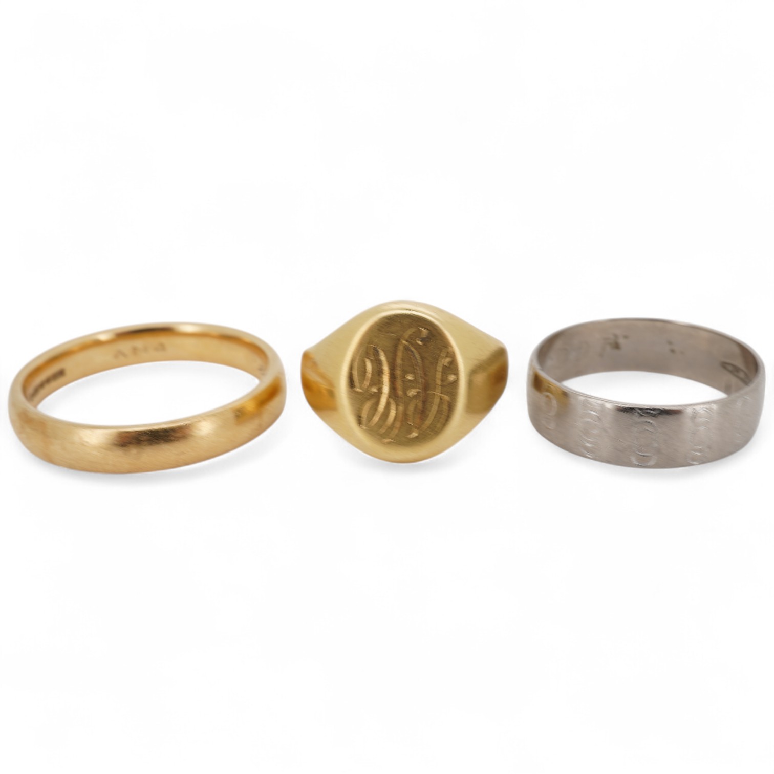 A 1990's 18ct gold wedding band, with engraved inscription, size U/V, a similar signet ring with engraved monogram and inscription, size I and an early 1970's 18ct white gold band, size O, gross weight 15.4 grams.